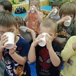 Dzieci piją świeżą wodę z kubeczków.